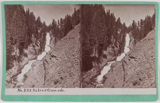 Two almost identical side-by-side black-and-white photographs of a waterfall tumbling down a mountainside covered with tall trees.