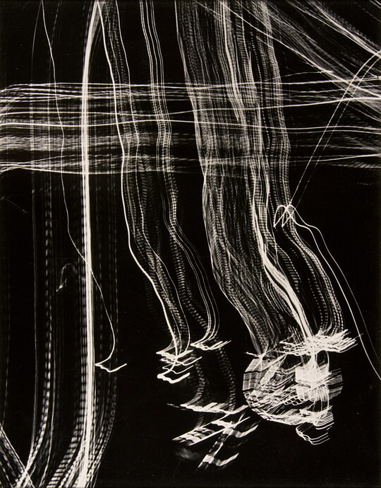 An abstract black-and-white photograph of streaks of white light intersecting at right angles across the page creating a plaid pattern.