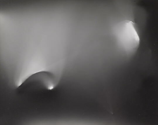 An abstract black-and-white photograph of foggy arcs of light against a black background.