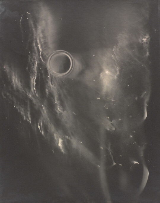 An abstract black-and-white photograph of what resembles a foggy galaxy against a black background.