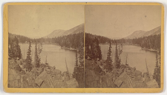 Two almost identical side-by-side sepia-toned photographs of a lake and rocky mountain landscape.