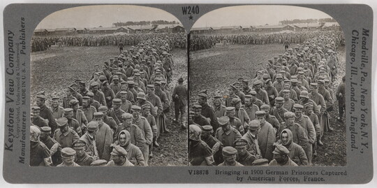 Two almost identical side-by-side black-and-white photographs of a long line of men, about four wide, in military clothing.