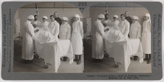 Two almost identical side-by-side black-and-white photographs of men and women in white hospital uniforms surrounding a person lying on a table covered under a white sheet.