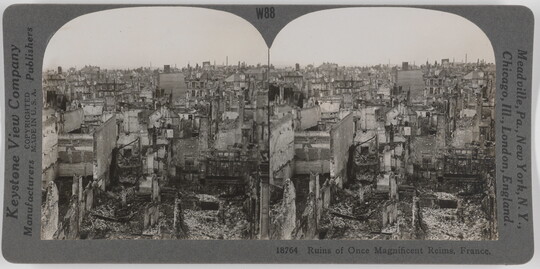 Two almost identical side-by-side black-and-white photographs of a city in ruins covered in debris.