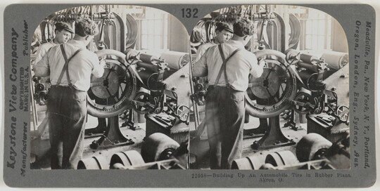 Two almost identical side-by-side black-and-white photographs of two White men in a factory working at a machine.