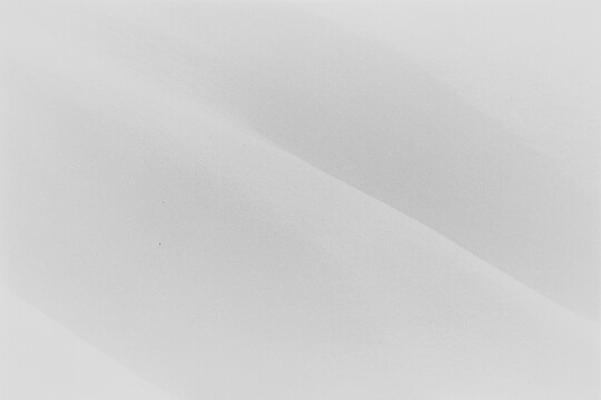 A black-and-white landscape photograph of snow covered hills.