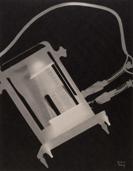 An abstract black-and-white photograph of a white and gray X-ray-like silhouette of a toaster and its electric cords.