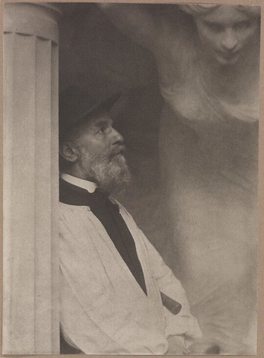 A black-and-white photograph of an older White man in profile leaning against a fluted column with what looks like a sculpture of a woman hovering over him.