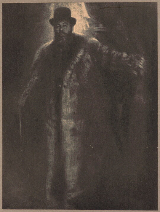 A dark, soft-focus black-and-white photograph of a tall, broad light-skinned man with a beard wearing a top hat and long fur coat.