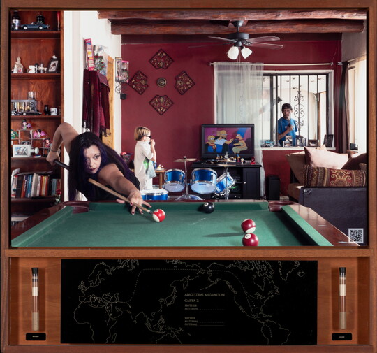 A color photograph of a medium-skinned woman playing pool; in the background, a young child stands next to a blue drum set watching TV, and a man looks through a window from the outside.