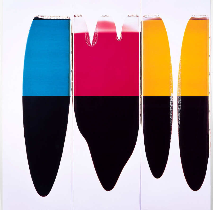 A color photograph of four vertically-oriented abstract stapes, the bottom half of each is black, and the tops are blue, red, and yellow.