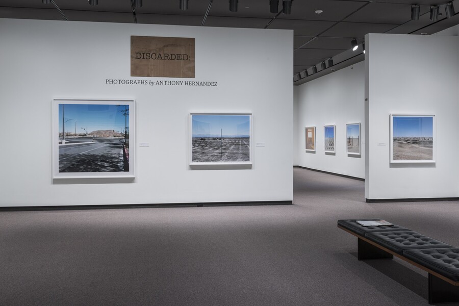 Overview of gallery entrance showing the exhibition title and two artworks to the left of a doorway into the exhibition.