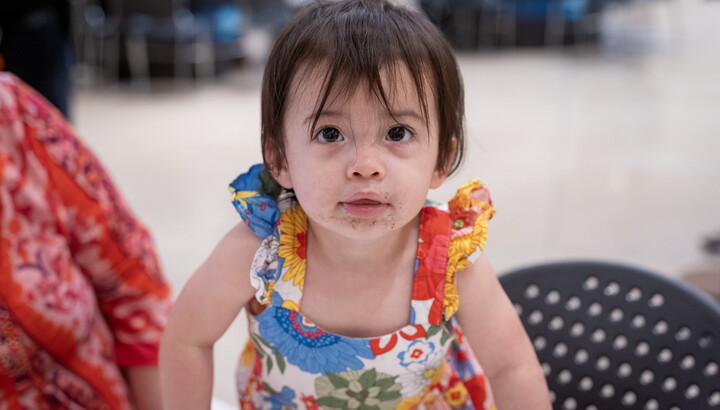 A close-up of a young child on an adult's lap in the Carter's Atrium.