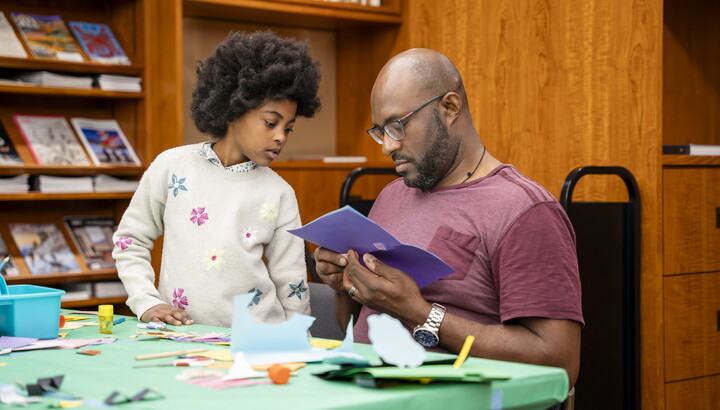 A Black man and pre-teen make art together at a table in the Carter Library.