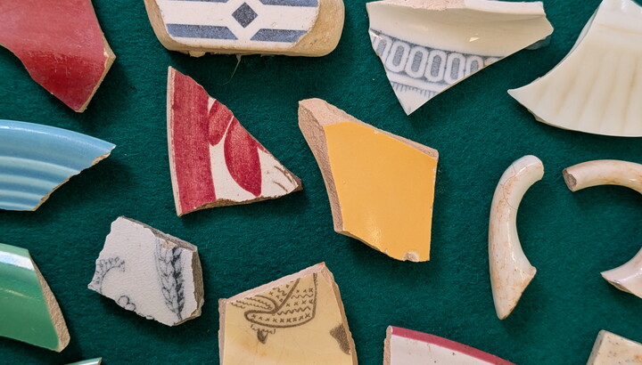 Pieces of ceramic laying on a green cloth.