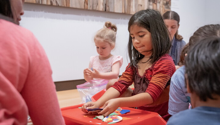 Several children make art on a lap desk in one of the Carter's galleries.