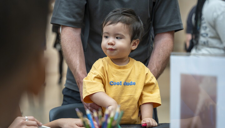 A small child uses crayons to color at a table in a Carter gallery.