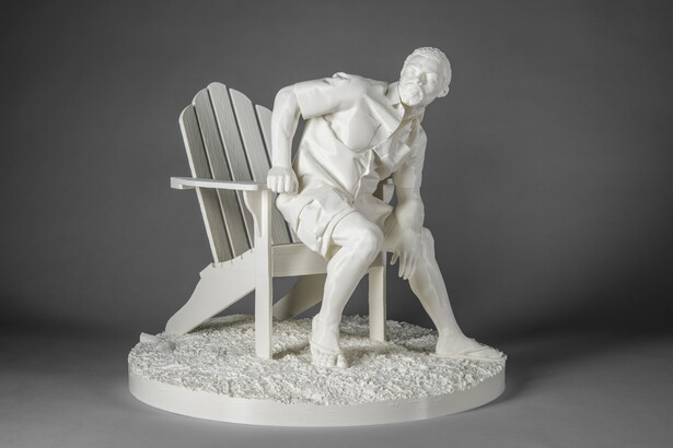 A white, 3-D printed sculpture of a muscled Black man dressed in casual clothing leaning forward as he sits on an Adirondack chair.