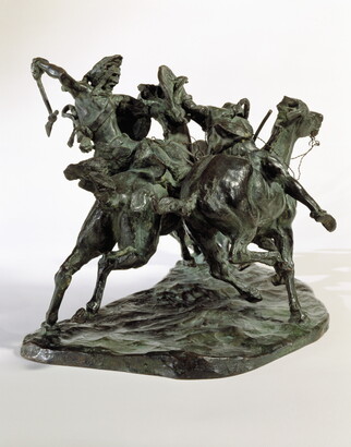 A bronze sculpture of two horses in mid-gallop, with both riders lunging toward a crouching man behind a shield.