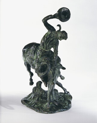 A bronze sculpture of a cowboy trying to ride a bucking horse.