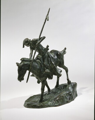 A bronze sculpture of an Indigenous man on horseback holding a spear pointed toward the ground as he studies footprints there.