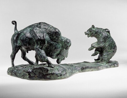 A bronze sculpture of a bison and a bear facing off.