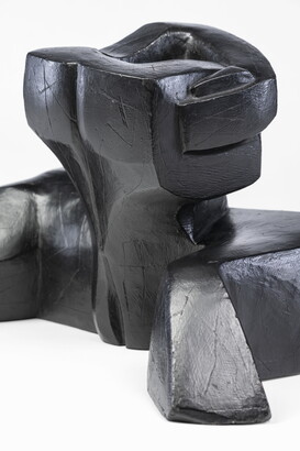 An abstract, black sculpture resembling a figure&#039;s head and shoulders.