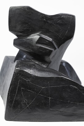 An abstract, black sculpture resembling a figure&#039;s head and shoulders.