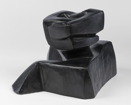 An abstract, black sculpture resembling a figure&#039;s head and shoulders.
