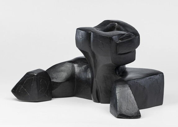 An abstract, black sculpture resembling a figure&#039;s head and shoulders.