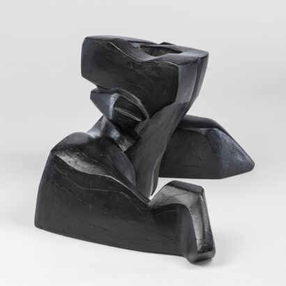 An abstract, black sculpture resembling a figure&#039;s head and shoulders.