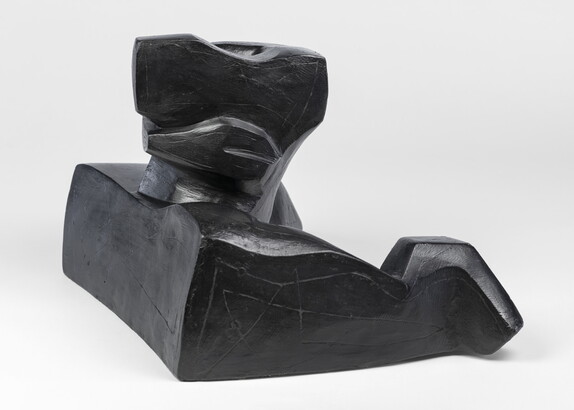 An abstract, black sculpture resembling a figure&#039;s head and shoulders.