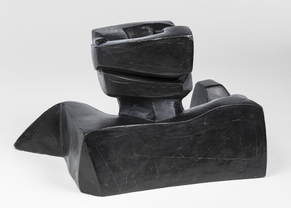 An abstract, black sculpture resembling a figure&#039;s head and shoulders.