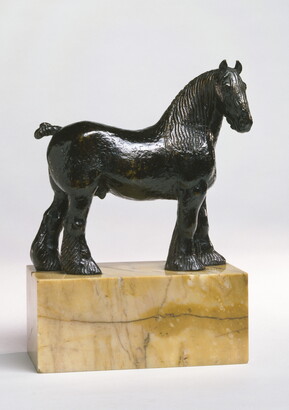 A bronze sculpture of a stallion with a bobbed tail and long hair on its legs below the knees standing on a stone base.