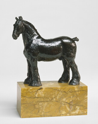 A bronze sculpture of a stallion with a bobbed tail and long hair on its legs below the knees standing on a stone base.