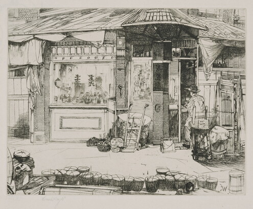 A black-and-white print of a person seated at work in front of a building with Asian details; a line of baskets on the street in the foreground.