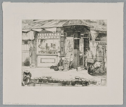 A black-and-white print of a person seated at work in front of a building with Asian details; a line of baskets on the street in the foreground.