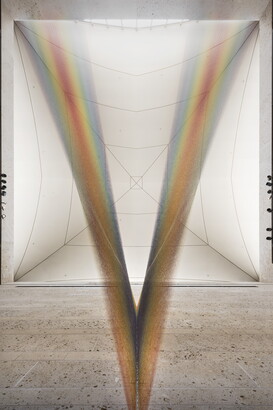 A large installation of multicolored sewing thread that stretches from one wall to the ceiling in the Carter&#039;s Atrium and looks like a rainbow.