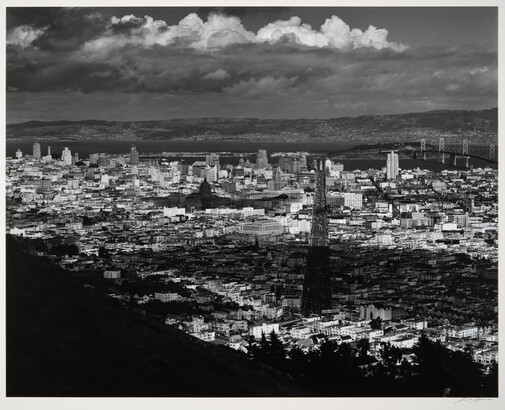 A black-and-white photograph of an arial view of San Francisco, parts of which are in shadow from clouds.