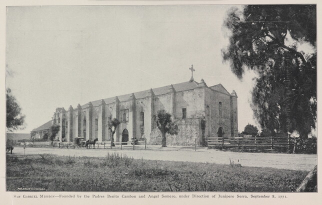 A black-and-white photograph of a mission church by a dirt road.