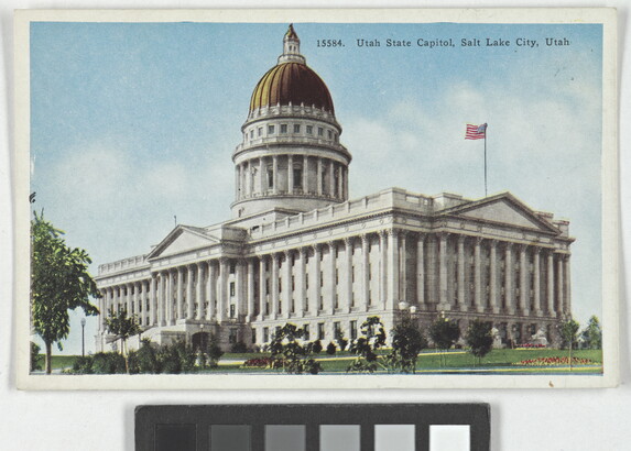 A color postcard of a gold domed government building with many columns.