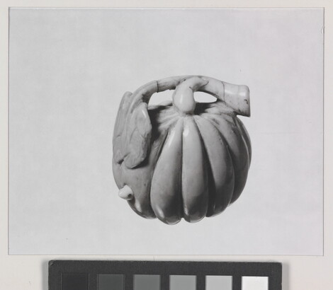A black-and-white photograph of a ceramic pumpkin.
