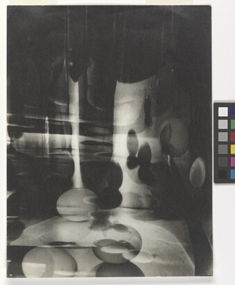 A black-and-white photograph of abstracted egg shapes layered and reflected on top of one another.