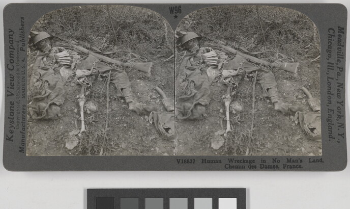 Two almost identical side-by-side black-and-white photographs of a human skeleton laying in the dirt amongst remnants of clothing and weapons.