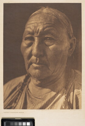A sepia-toned portrait photograph of a close up of an older Indigenous woman with her hair in braids.