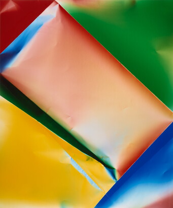 A color photograph of what looks like crinkled paper of orange and yellow rectangles surrounded by a blue, green, and red triangles.