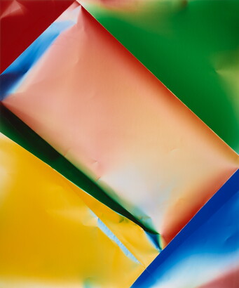 A color photograph of what looks like crinkled paper of orange and yellow rectangles surrounded by a blue, green, and red triangles.