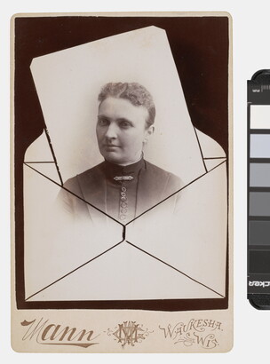 A sepia-toned studio photograph in which the bust of a White woman seems to be popping out of an envelope.