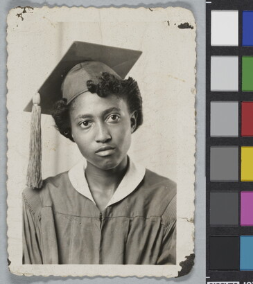 A black-and-white studio photograph of the bust of a Black woman in a graduation cap and gown.