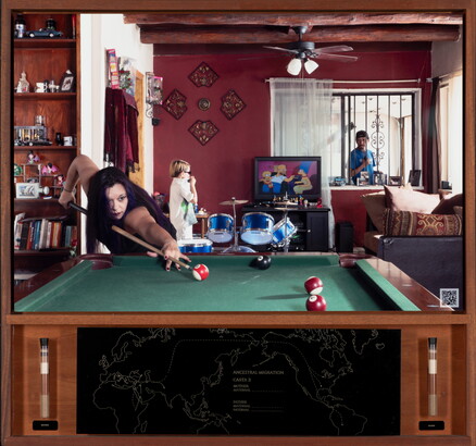 A color photograph of a medium-skinned woman playing pool; in the background, a young child stands next to a blue drum set watching TV, and a man looks through a window from the outside.